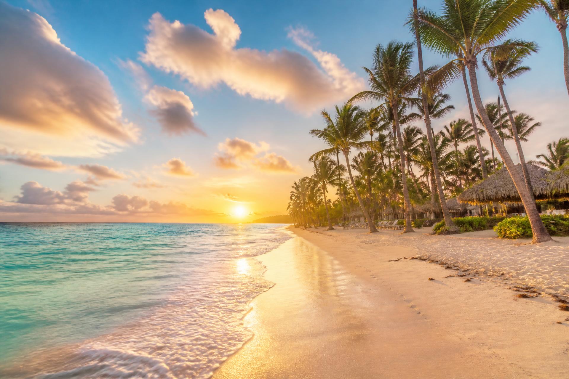 Sunset over a Punta Cana beach with palm trees and turquoise water